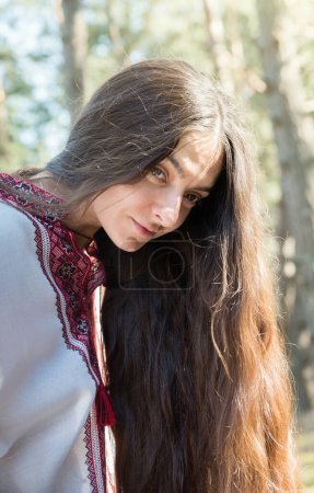 Téléchargez les photos : Fille ukrainienne aux cheveux longs dans une chemise nationale brodée dans la forêt - en image libre de droit