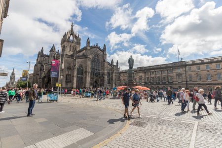Photo for Edinburgh festival 2022 people watching street performance at Royal Mile with St Giles Cathedral on the background in Scotland, Edinburgh - Royalty Free Image