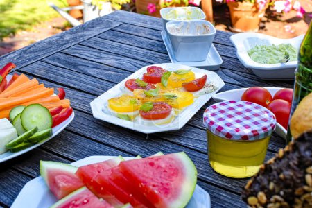 Téléchargez les photos : Table de petit déjeuner en bois dans le jardin avec divers éléments nutritifs. - en image libre de droit