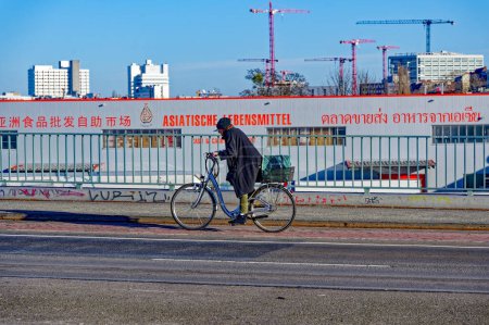 Foto de Berlín, Alemania - 28 de enero de 2024: Escena callejera con ciclista en un carril bici en Berlín. - Imagen libre de derechos
