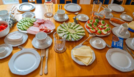 Téléchargez les photos : Berlin, Allemagne - 17 février 2024 : Table de petit déjeuner avec vaisselle, couverts et un grand choix de nourriture. - en image libre de droit