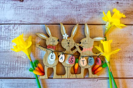 Osterhasen aus Holz mit Dekoration und dem Text Ostern auf Eiern.