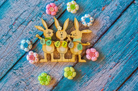 Wooden Easter bunnies with decoration and the text Easter written on eggs.