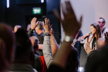 Téléchargez les photos : Les mains dans l'air des gens qui louent Dieu au service de l'église - en image libre de droit