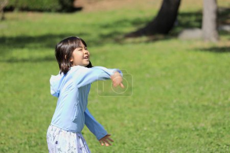 Foto de Japonesa estudiante chica lanzando un balón (8 años de edad) - Imagen libre de derechos