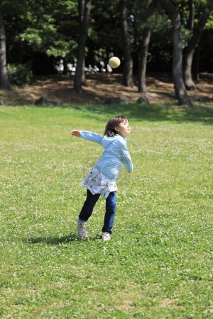 Foto de Japonesa estudiante chica lanzando un balón (8 años de edad) - Imagen libre de derechos