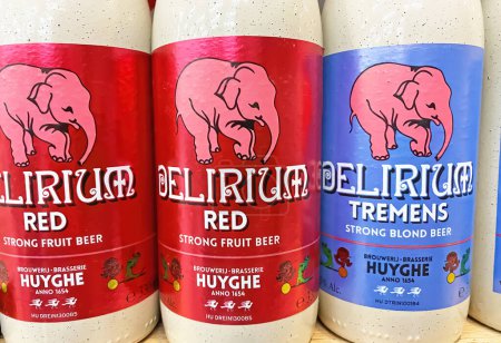 Foto de Viersen, Alemania - 9 de marzo. 2023: Primer plano de las botellas belgas Delirium cerveza fuerte de la cervecería Huyghe en el estante de la tienda alemana - Imagen libre de derechos