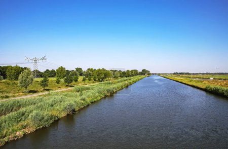 Foto de Hermoso canal de agua interior holandés recto, verde paisaje rural, carril bici ribereña Brabante Septentrional. cerca de S-Hertogenbosch, Países Bajos - Imagen libre de derechos