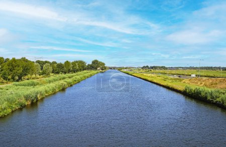 Foto de Hermoso canal de agua interior holandés recto, verde paisaje rural, carril bici ribereña Brabante Septentrional. cerca de S-Hertogenbosch, Países Bajos - Imagen libre de derechos