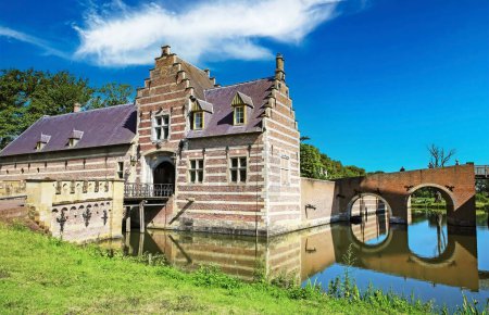 Foto de Hermoso foso idílico con castillo medieval y puente - Kasteel Heeswijk, Países Bajos - Imagen libre de derechos
