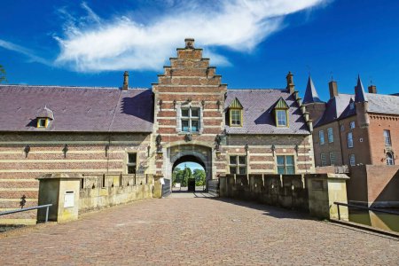 Téléchargez les photos : Passerelle du pont menant à l'entrée du château médiéval contre le ciel bleu de l'été - Kasteel Heeswijk, Pays-Bas - en image libre de droit