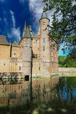 Téléchargez les photos : Beaux douves d'eau pittoresques idylliques avec reflet du mur et de la tour du château médiéval - Kasteel Heeswijk, Pays-Bas - en image libre de droit