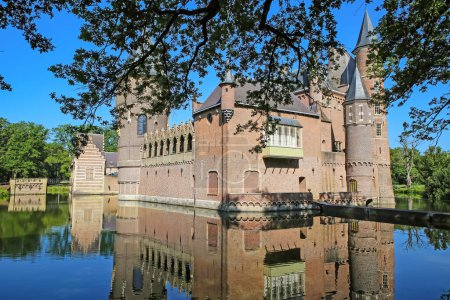 Téléchargez les photos : Beau jardin vert hollandais avec fossés d'eau et reflets du mur et de la tour du château médiéval - Kasteel Heeswijk, Pays-Bas - en image libre de droit