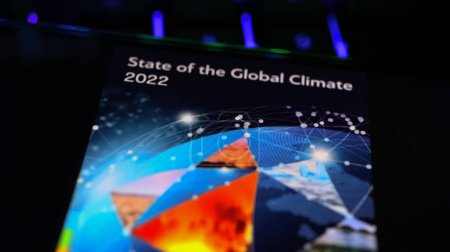 Téléchargez les photos : Viersen, Allemagne - 9 mars. 2024 : Gros plan de l'écran du smartphone sur le clavier de l'ordinateur avec l'Organisation météorologique mondiale État du climat mondial à l'OMM - en image libre de droit