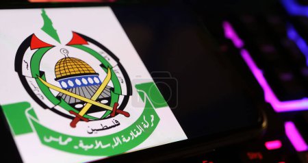 Téléchargez les photos : Viersen, Allemagne - 1er mai. 2024 : Smartphone avec emblème du Hamas sur le clavier de l'ordinateur - en image libre de droit