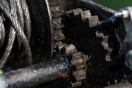 Foto de Close-up and detail shot of a greased winch. You can see the gears, the pulley and the steel cable. - Imagen libre de derechos