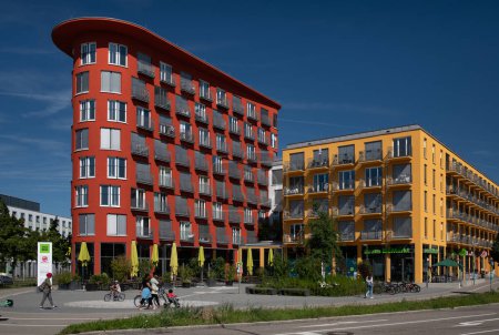Photo for There are two large residential buildings in Augsburg that are used as dormitories. The houses are red and yellow. There are many windows and balconies on the facade. Shops on the ground floor. - Royalty Free Image