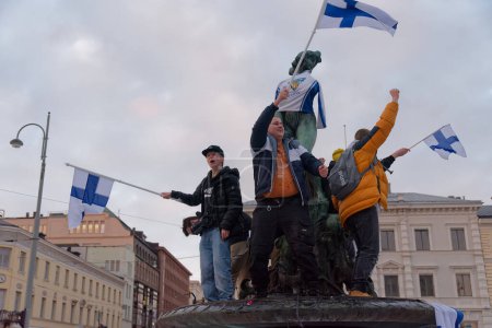 Photo for Helsinki, Finland - February 20, 2022: Finnish ice hockey fans celebrate Finlands first-ever olympic gold medal in ice hockey in Peking 2022 olympics at the statue of Havis Amanda with a Finnish national ice hockey team jersey. - Royalty Free Image