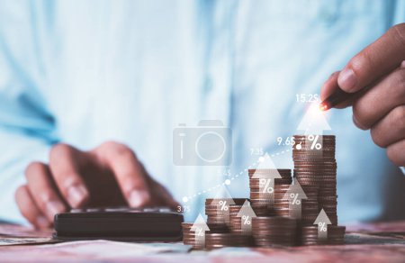 Businessman drawing increasing graph with coin stacking for increase financial interest rate and business investment growth from dividend profit concept.