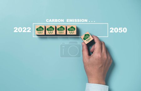 Téléchargez les photos : Un homme tenant une icône de réduction des émissions de CO2 avec une charge virtuelle pour réduire les émissions de CO2, l'empreinte carbone et le crédit carbone pour limiter le réchauffement climatique, Protocole Kyoto2050. - en image libre de droit