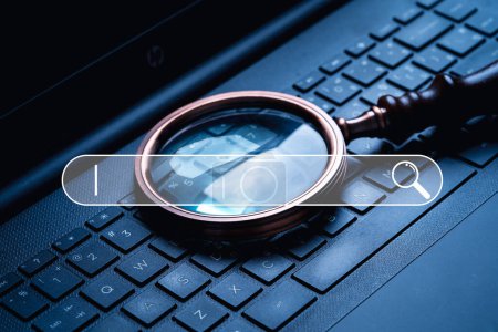 Photo for Magnifier glass on laptop computer keyboard with search bar icon for Search Engine Optimization or SEO concept to find information by internet connection. - Royalty Free Image