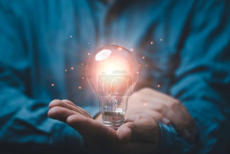 Photo for Businessman holding glowing lightbulb  with copy space for creative thinking idea and problem solving concept. - Royalty Free Image