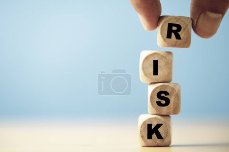 Pantalla de impresión de texto de riesgo de mano en cubo de bloque de madera para análisis y gestión de riesgos de banca financiera, concepto de bajo rendimiento de bajo riesgo.