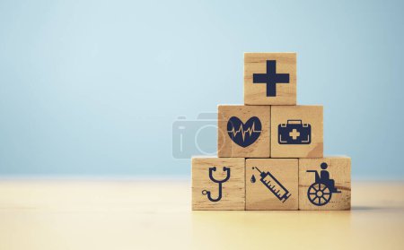 Foto de Iconos médicos y de atención médica imprimen pantalla en bloque de madera para un seguro de bienestar saludable y concepto de seguridad. - Imagen libre de derechos