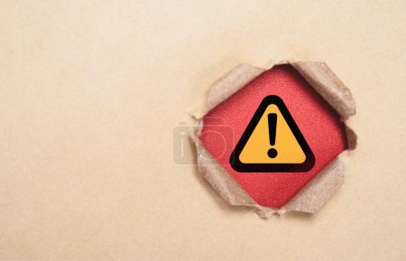 Foto de Señal de advertencia de precaución triángulo amarillo y negro en papel perforado marrón para el concepto de exclamación de alarma de error de notificación y tecnología de mantenimiento. - Imagen libre de derechos
