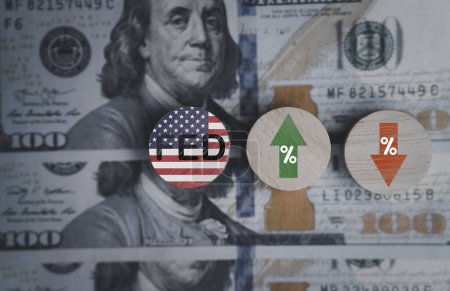 Foto de FED wording with up and down arrow on USD dollar banknote for Federal reserve increase and decrease interest rate control which effect to America and world economic growth concept. - Imagen libre de derechos