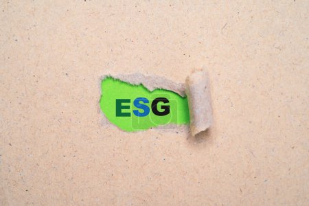 Téléchargez les photos : Libellé ESG à l'intérieur du papier déchiré pour le développement durable des organisations et l'intégration du concept de gouvernance sociale environnementale. - en image libre de droit