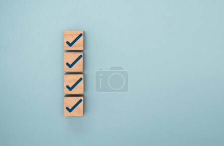 Photo for Blue correct sign and tick check mark to wooden cube block with copy space for checklist of ISO quality control and approve business product concept. - Royalty Free Image