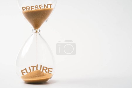 Photo for Present wording dropping from top of hourglass to future wording   and future inside of sand clock on white background with copy space for continuous improvement concept. - Royalty Free Image