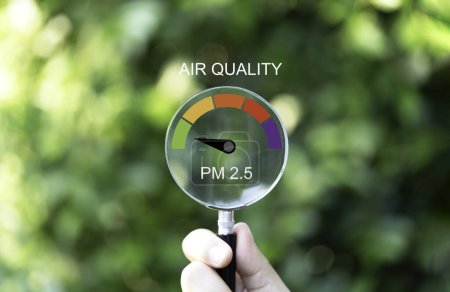 Téléchargez les photos : Loupe à main avec une bonne échelle d'indicateur de la qualité de l'air sur fond de verdure qui vérifient les PM 2,5 ou les particules 2,5 microns pour l'effet de la pollution de l'air sur la santé et le mode de vie concept. - en image libre de droit