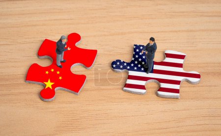 Miniatur-Geschäftsleute stehen auf China und den USA Flagge Puzzle für Unternehmen und staatliche Unternehmen zwischen beiden Ländern nach dem Konflikt gehören Handelskrieg und militärischen Krieg Konzept.
