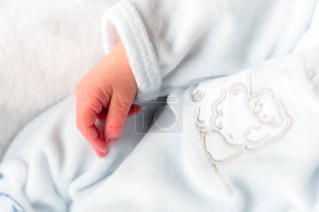 Téléchargez les photos : Gros plan d'une main d'un nouveau-né avec des vêtements blancs - en image libre de droit