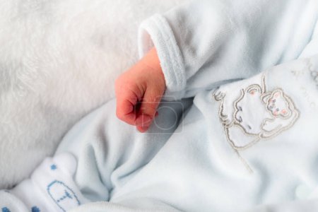 Foto de El primer plano de una mano de un recién nacido con ropa blanca - Imagen libre de derechos