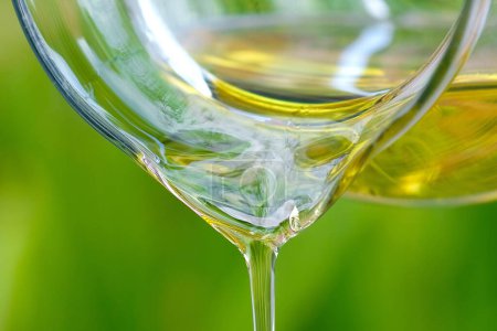 Téléchargez les photos : Verser de l'huile d'olive dans un bol en verre à la cuisine en pierre et à l'intérieur vue sur le jardin vert. Préparez-vous pour le concept de cuisine. Santé et Beauté Concept. - en image libre de droit