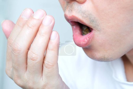 Mundgesundheit Männer benutzen Hände, um Mundgeruch und Atmung zu kontrollieren.