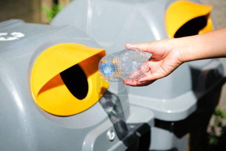 Por favor, deseche la botella de plástico en el tanque. Un hombre tira basura en el cubo de basura por separado para desecharla como residuos peligrosos.
 ,