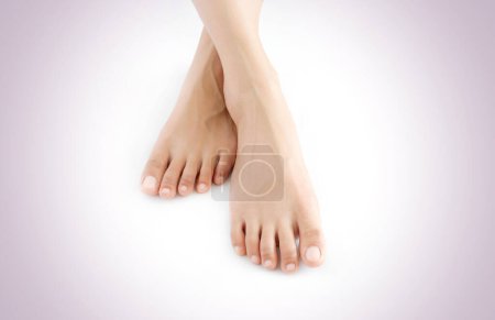 Schöne weibliche Beine und Füße auf weißem Hintergrund. Konzept Schönheit und Hydratation der Haut.