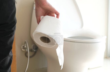 La main de l'homme, il tient un rouleau de papier toilette Aller à la salle de bain Toilettes fond de toilette