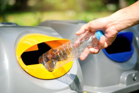 Veuillez jeter la bouteille en plastique dans le réservoir. Un homme jette des ordures dans la poubelle par des ordures séparées pour les jeter comme des déchets dangereux ,