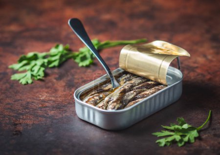 Photo for Canned sardines with olive oil open on a dark brown table with a fork and parsley. Ready for eat. - Royalty Free Image