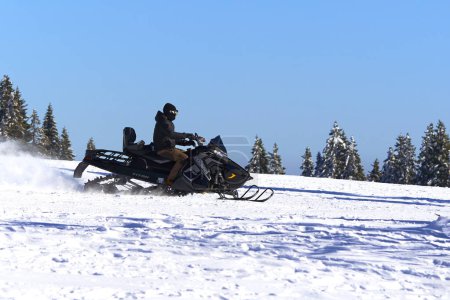 Foto de Feldberg, Alemania - 08 de febrero de 2023: Snowmobile Polaris Titan 800. Vehículo para uso universal en condiciones extremas de operación.Invierno en bosque negro. Conducir en la pista de esquí. - Imagen libre de derechos