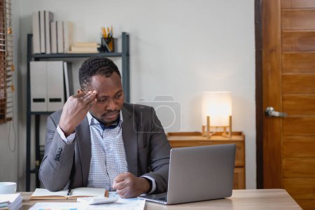 Photo for Concept Burnout Syndrome. African American businessman feels uncomfortable working, which is caused by stress, accumulated from unsuccessful work And less rest body. Consult a specialist psychiatrist. - Royalty Free Image