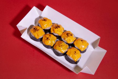 Photo for A box of sushi roll with a cheese on top - Royalty Free Image