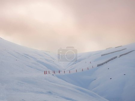Photo for A snowy landscape of ski slopes with a sunset sky, Ampriu mountain pass, Cerler, Huesca, Aragonese Pyrenees, Spain - Royalty Free Image