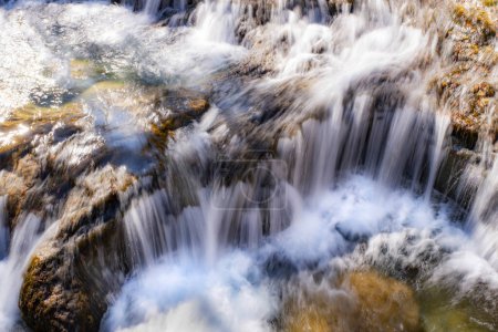 Téléchargez les photos : Longue exposition dans une petite cascade dans une rivière de montagne d'eaux douces et pures, torrent de fonte des neiges de montagne - en image libre de droit