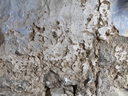 Textur einer maroden alten Mauer, mit einer teilweise reparierten abplatzenden, rissigen Betonwand, horizontal